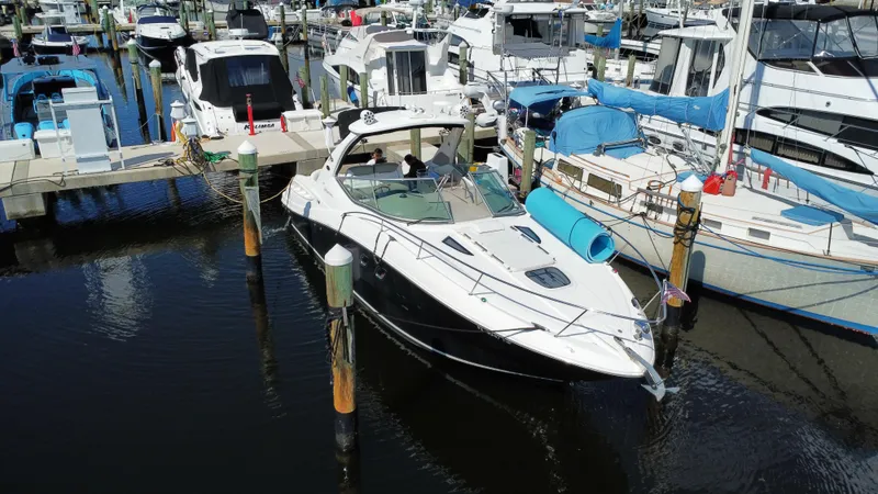 Slide: The Image of 2007 Sea Ray 310 Sundancer docked at a marina with other boats. - 3