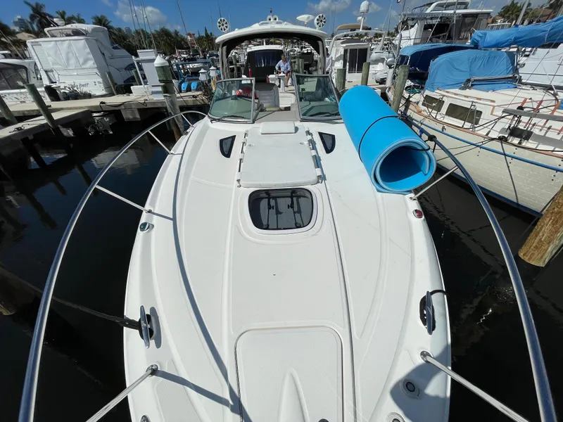 Slide: The Image of 2007 Sea Ray 310 Sundancer docked, featuring spacious deck and blue mat. - 6