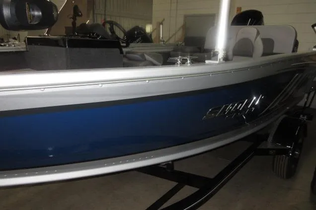 Slide: The Image of 2023 Smoker Craft Pro Angler XL 171 boat with blue and silver exterior in a showroom. - 4