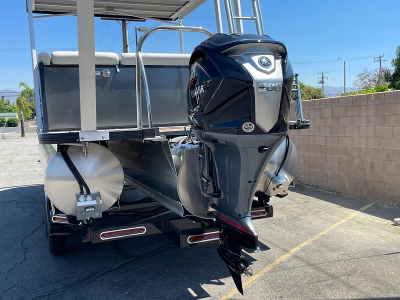 Slide: The Image of 2024 Avalon 2585 Catalina Funship with Yamaha outboard motor, parked outdoors. - 4