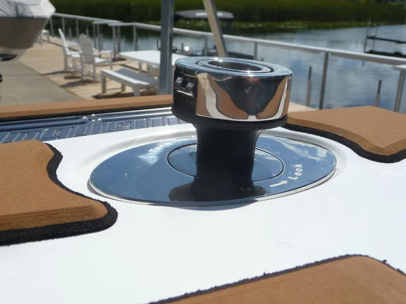 Slide: The Image of Close-up of a 2023 Malibu 21 LX boat's polished metal component by the water. - 16