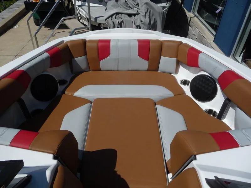 Slide: The Image of 2023 Malibu 21 LX boat interior with brown, gray, and red cushioned seating. - 3