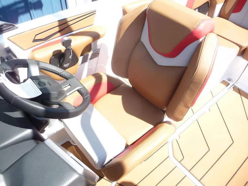 Slide: The Image of 2023 Malibu 21 LX boat interior with tan, white, and red seating and steering wheel. - 4