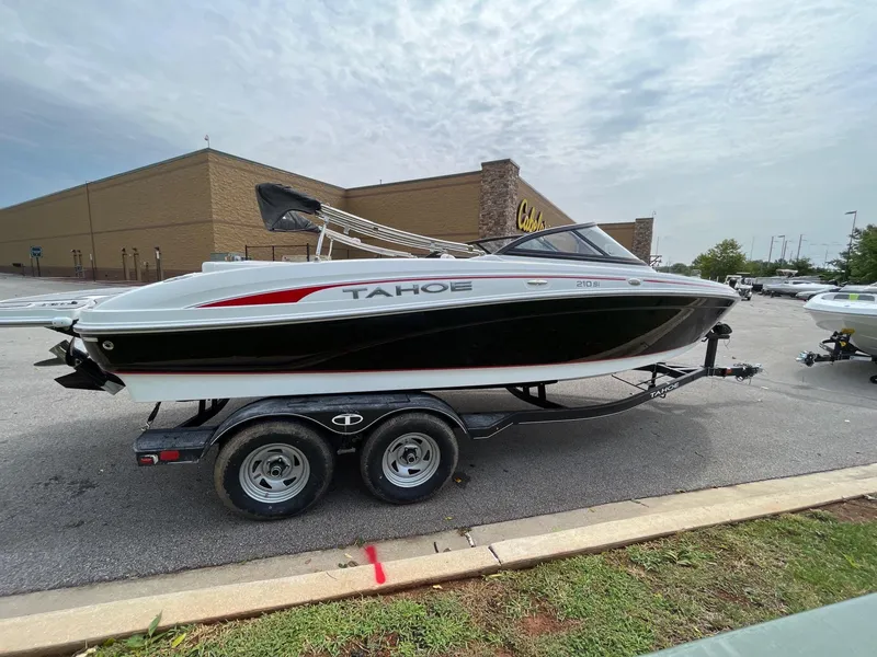 Slide: The Image of 2024 Tahoe 210 Si boat on a trailer in a parking lot. - 2