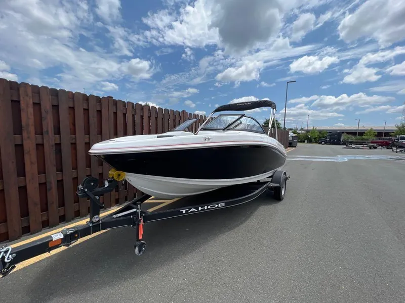 Slide: The Image of 2024 Tahoe 185 S boat on trailer under a partly cloudy sky. - 0