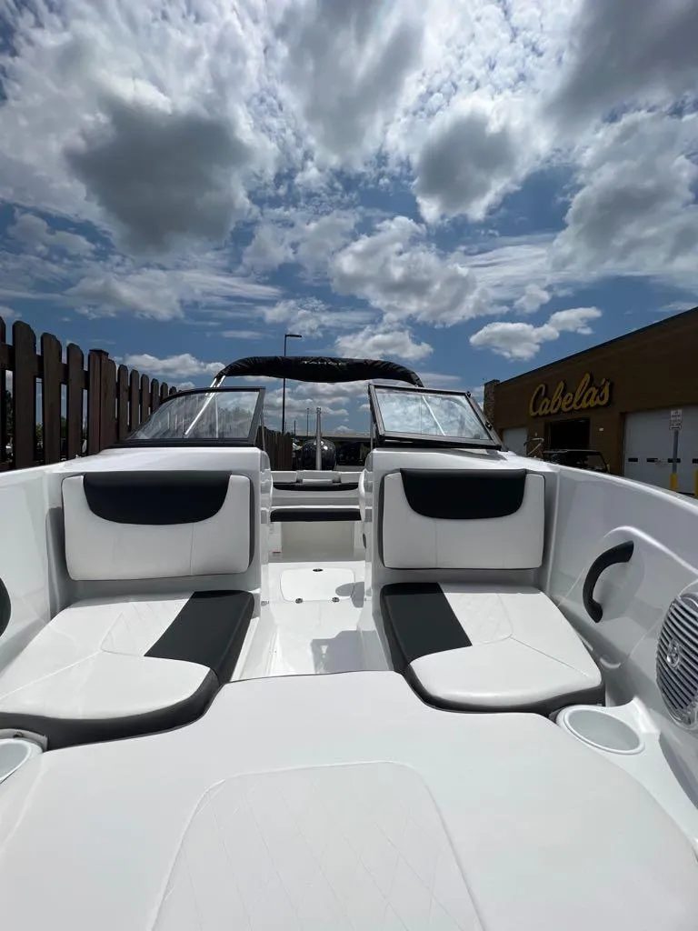 Slide: The Image of 2024 Tahoe 185 S boat with white and black seating, displayed outdoors under a cloudy sky. - 2