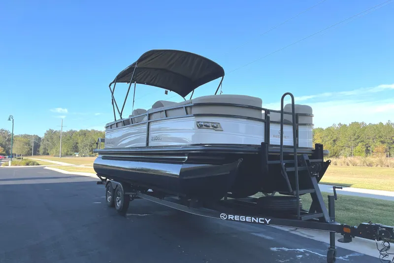 Slide: The Image of 2024 Regency 230 DL3 pontoon boat on trailer with canopy. - 1