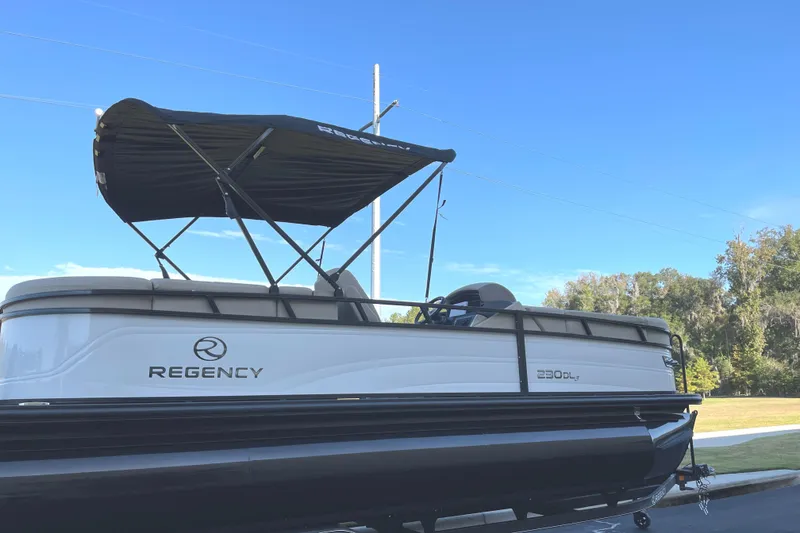 Slide: The Image of 2024 Regency 230 DL3 pontoon boat with canopy on trailer. - 4
