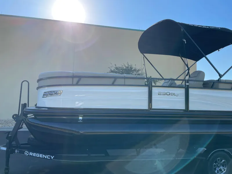 Slide: The Image of 2024 Regency 230 DL3 pontoon boat with canopy in sunlight. - 5