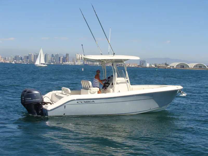 Slide: The Image of 2016 Cobia 237 Center Console boat on water with city skyline in background. - 0
