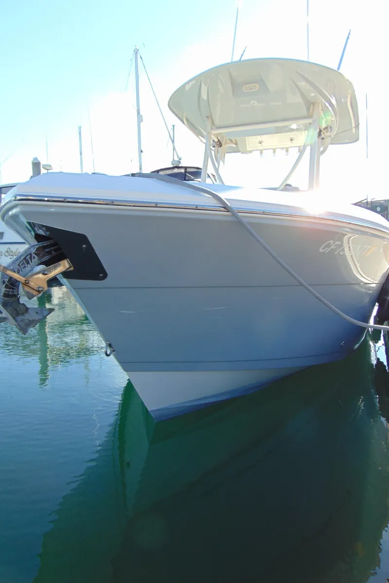 Slide: The Image of 2016 Cobia 237 Center Console boat docked in calm water. - 1