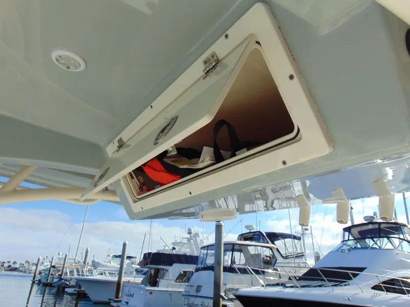 Slide: The Image of 2016 Cobia 237 Center Console storage compartment open at marina. - 12