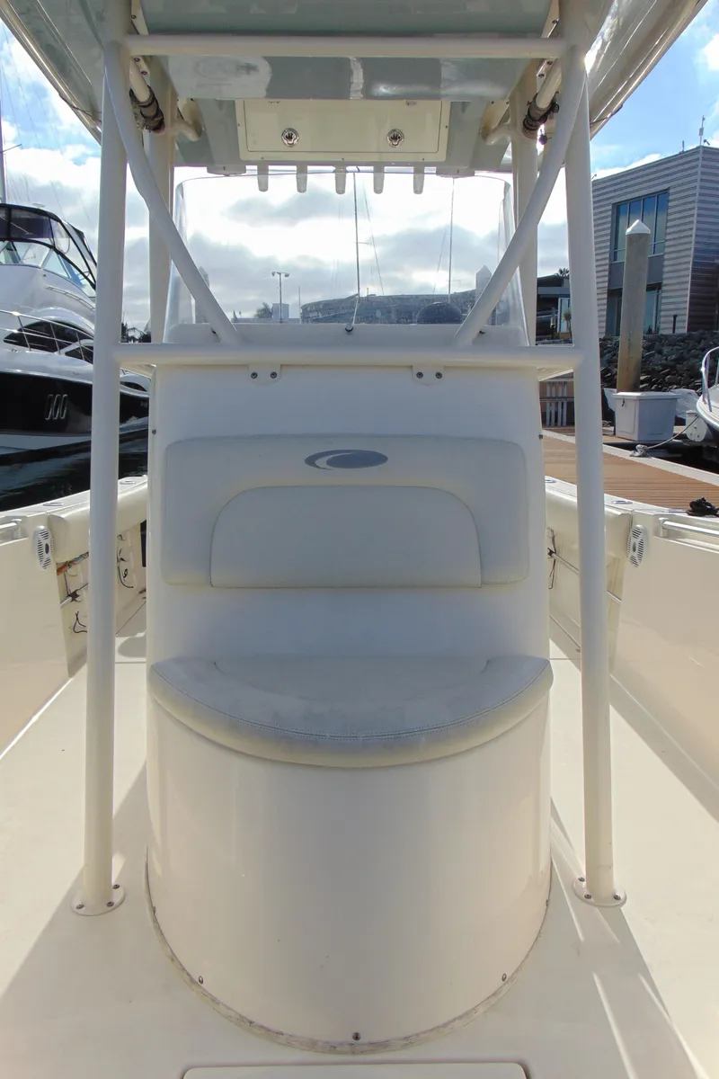 Slide: The Image of 2016 Cobia 237 Center Console boat, featuring a central seating area and overhead storage. - 19
