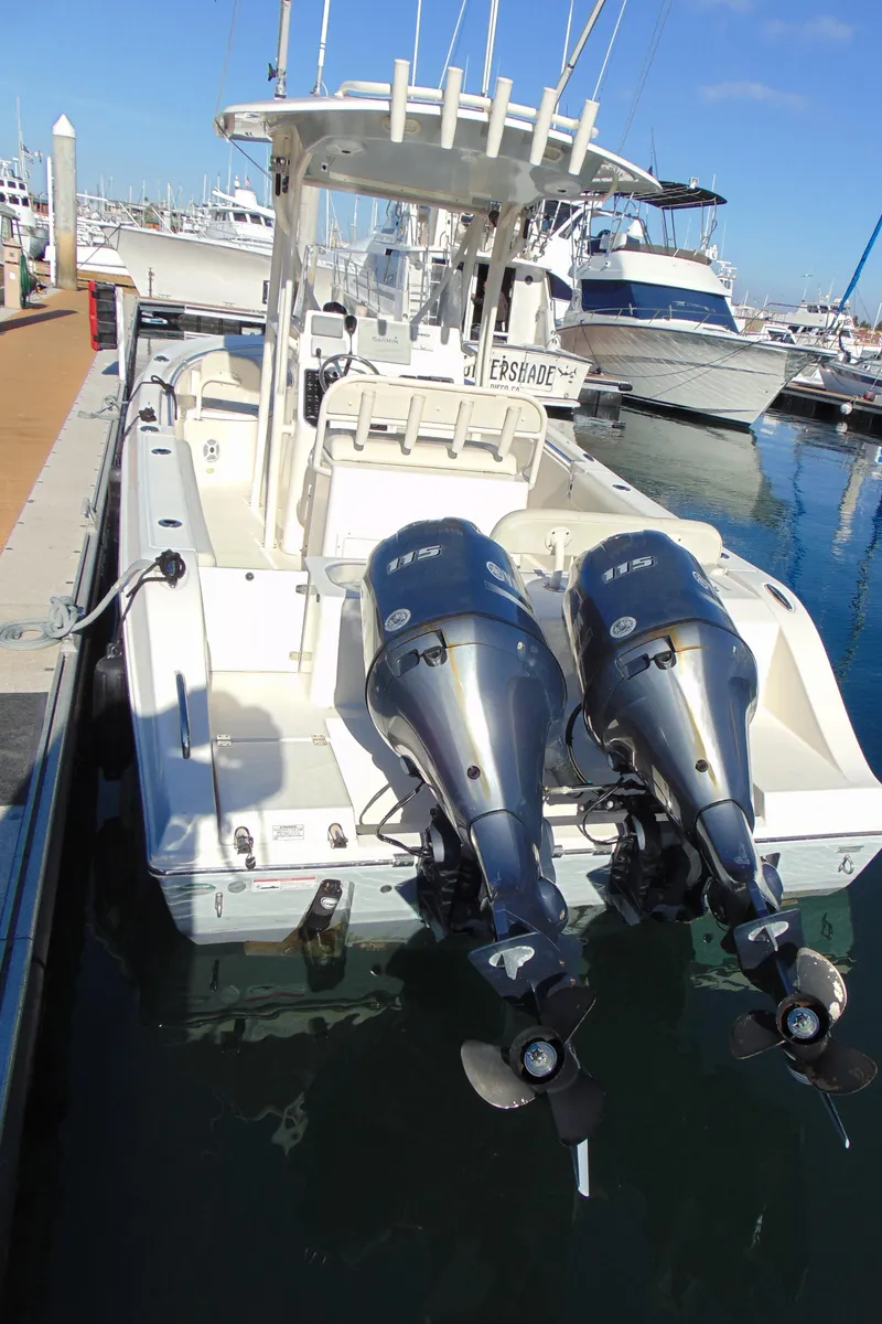 Slide: The Image of 2016 Cobia 237 Center Console boat docked with twin outboard engines. - 2