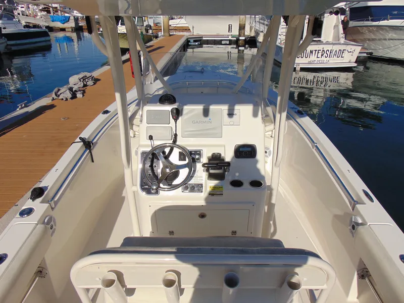 Slide: The Image of 2016 Cobia 237 Center Console boat at dock, featuring helm and controls. - 20