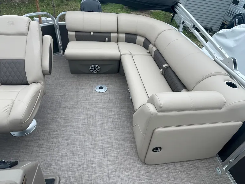 Slide: The Image of 2023 Sun Tracker Party Barge 20 DLX interior with beige seating and carpeted floor. - 11