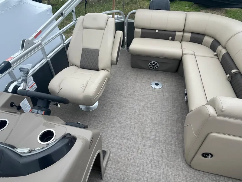 Slide: The Image of 2023 Sun Tracker Party Barge 20 DLX interior with beige seating and helm. - 13