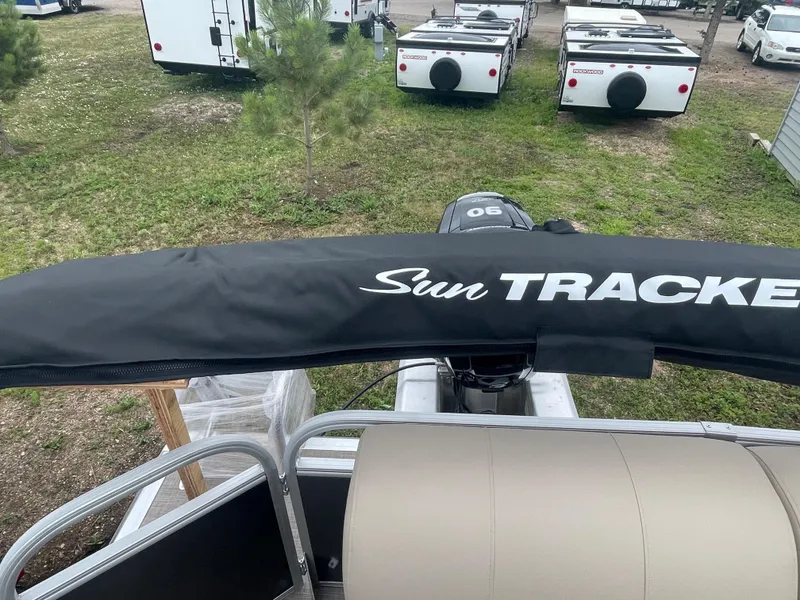 Slide: The Image of 2023 Sun Tracker Party Barge 20 DLX pontoon boat with covered motor, parked outdoors. - 7