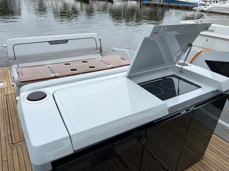Slide: The Image of Fairline F//Line 33 yacht kitchen area with stove, 2022 model, docked by the water. - 11