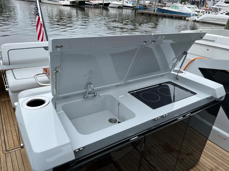 Slide: The Image of Fairline F//Line 33 yacht outdoor kitchen with sink and stove, docked at marina, 2022 model. - 13