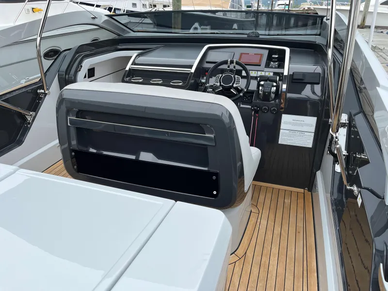 Slide: The Image of 2022 Fairline F//Line 33 yacht cockpit with modern controls and teak flooring. - 14