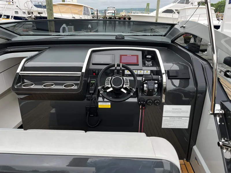 Slide: The Image of 2022 Fairline F//Line 33 yacht cockpit with modern steering and navigation controls. - 19