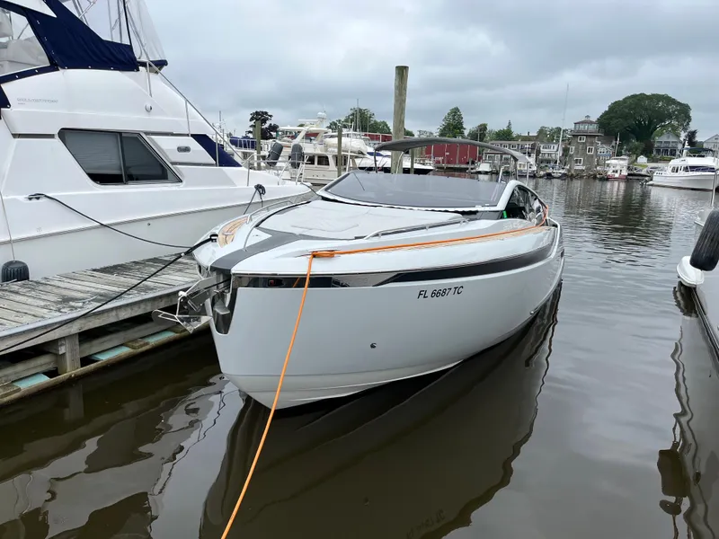 Slide: The Image of 2022 Fairline F//Line 33 yacht docked at marina, sleek design, overcast sky. - 2