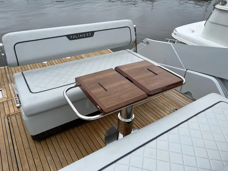 Slide: The Image of Fairline F//Line 33 yacht interior, 2022 model, featuring elegant seating and wooden table. - 7