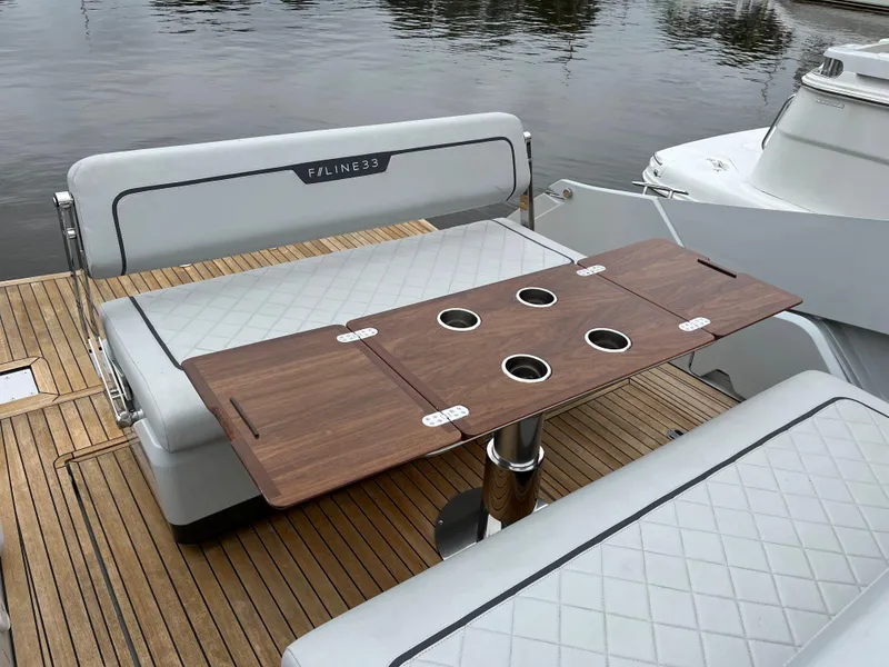 Slide: The Image of Fairline F//Line 33 yacht 2022, featuring elegant seating and a wooden table on deck. - 9