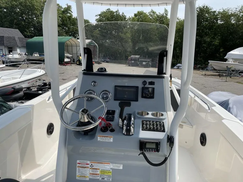 Slide: The Image of 2023 Bayliner Trophy 24 CC center console boat dashboard with steering wheel and controls. - 8