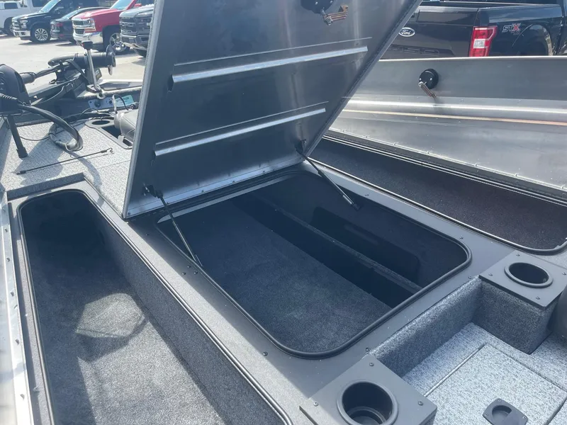 Slide: The Image of 2024 Tracker Pro Team 190 TX boat, docked under a sunny sky, showcasing interior seating and controls. - 11