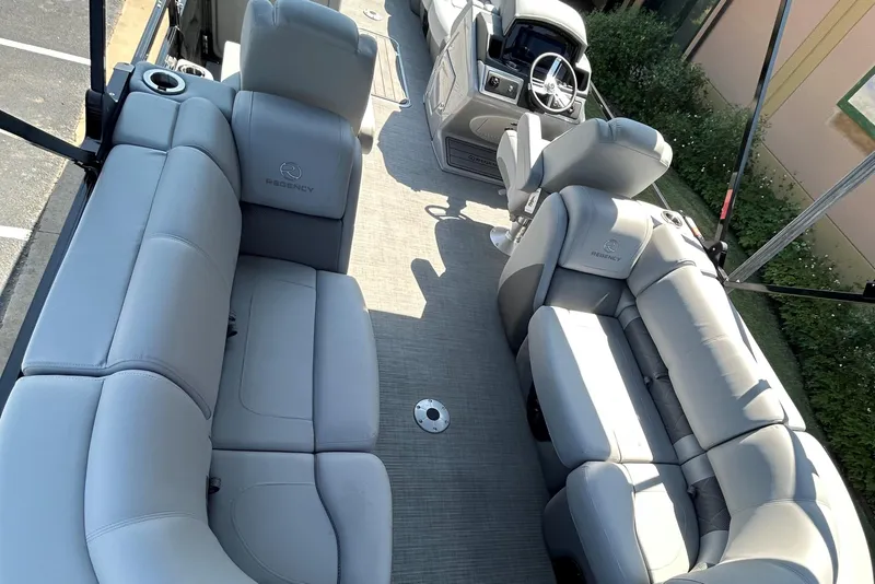 Slide: The Image of 2024 Regency 250 LE3 pontoon boat interior with plush seating and modern helm. - 6