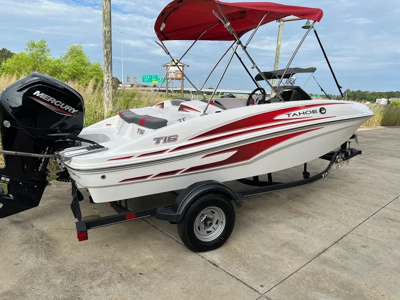 Slide: The Image of 2024 Tahoe T16 boat with red canopy on trailer, featuring Mercury outboard motor. - 1