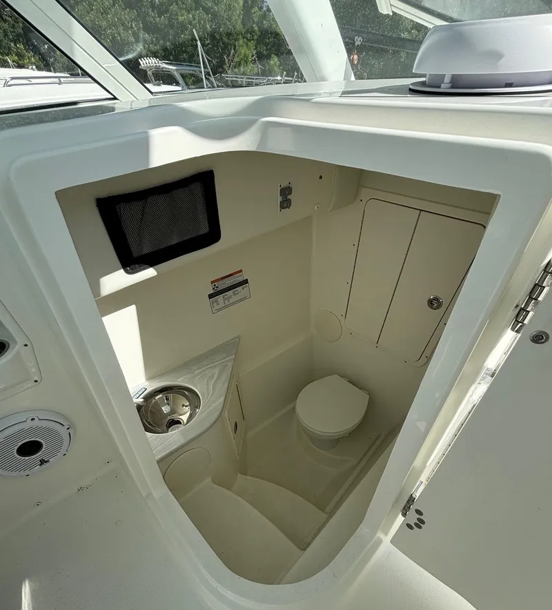 Slide: The Image of 2024 World Cat 296 DC boat interior with compact bathroom and sink. - 14