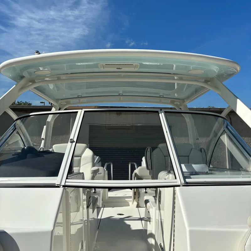 Slide: The Image of 2024 World Cat 296 DC boat with open cockpit and hardtop under a clear blue sky. - 16