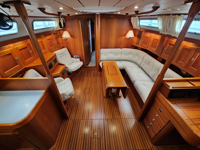 Slide: The Image of Luxurious 2009 Hallberg-Rassy 54 yacht interior with elegant wood finish and comfortable seating. - 12