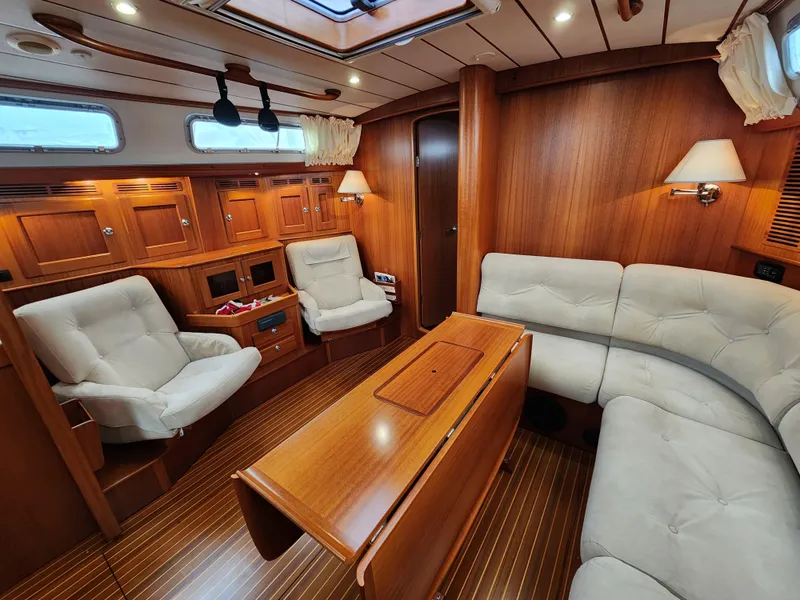 Slide: The Image of Luxurious 2009 Hallberg-Rassy 54 yacht interior with elegant wood finish and comfortable seating. - 16