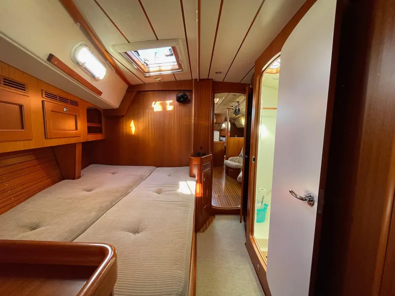 Slide: The Image of Interior of 2009 Hallberg-Rassy 54 yacht, featuring cozy wooden cabin and comfortable bedding. - 20