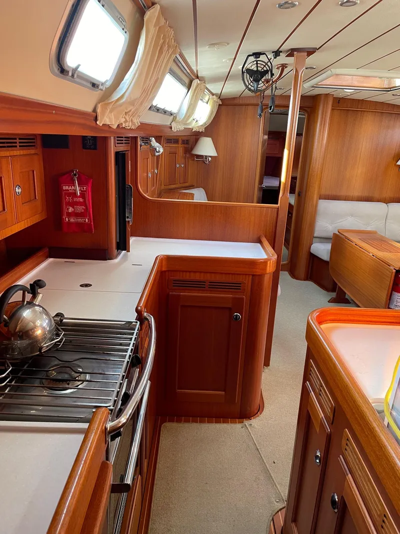 Slide: The Image of Interior of 2009 Hallberg-Rassy 54 yacht with wooden cabinetry and modern kitchen amenities. - 23