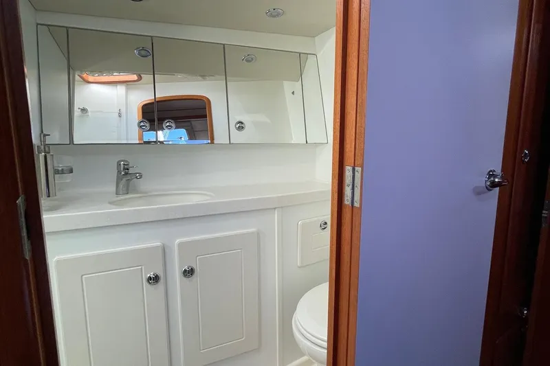Slide: The Image of Bathroom interior of 2009 Hallberg-Rassy 54 yacht, featuring mirrored cabinets and modern fixtures. - 28