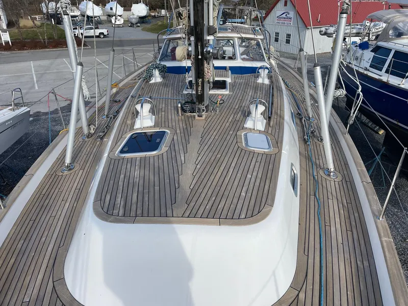 Slide: The Image of 2009 Hallberg-Rassy 54 sailboat with teak deck, docked at a marina. - 39