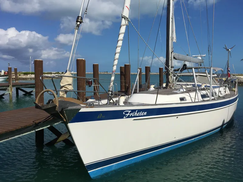 Slide: The Image of 2009 Hallberg-Rassy 54 sailboat docked at a marina under a blue sky. - 4