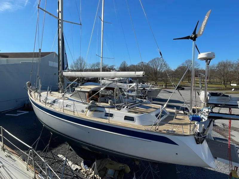 Slide: The Image of 2009 Hallberg-Rassy 54 sailboat on land, showcasing deck and mast under clear blue sky. - 40