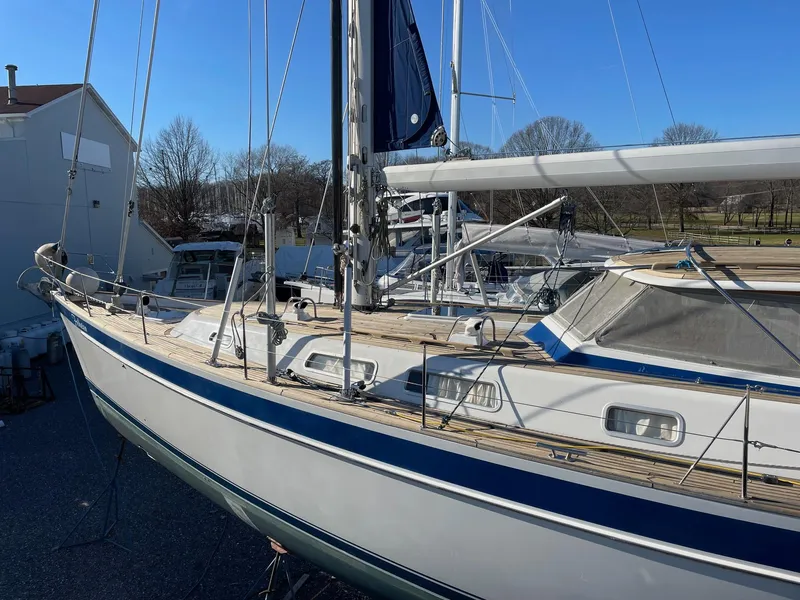 Slide: The Image of 2009 Hallberg-Rassy 54 sailboat with blue accents, docked outdoors under clear skies. - 43