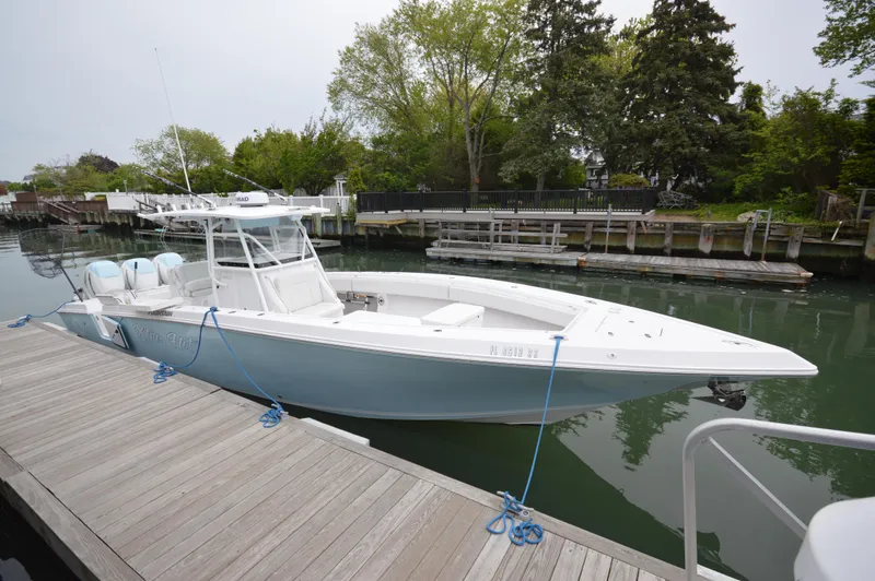 The Image of 2017 Fountain 38 Center Console boat docked by a wooden pier. - 0