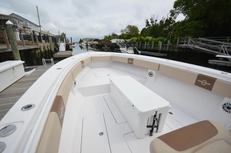 Slide: The Image of 2017 Fountain 38 Center Console boat docked at a marina, featuring spacious seating and storage. - 14
