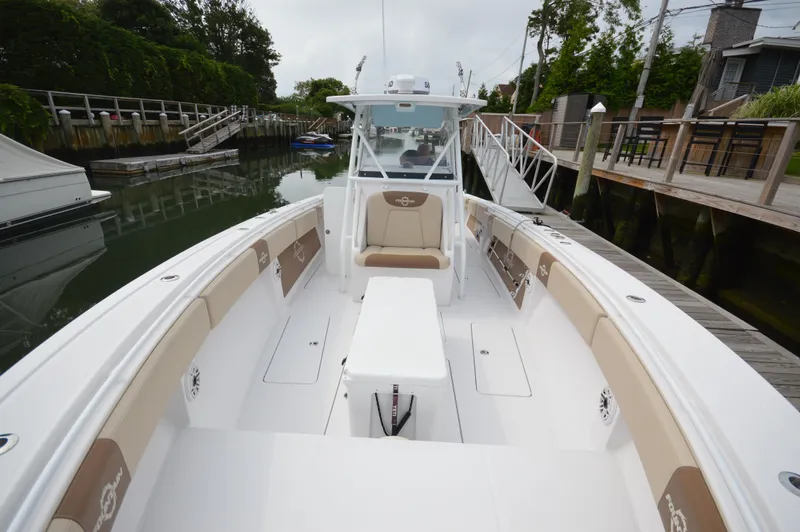 Slide: The Image of 2017 Fountain 38 Center Console boat docked, featuring spacious seating and sleek design. - 16