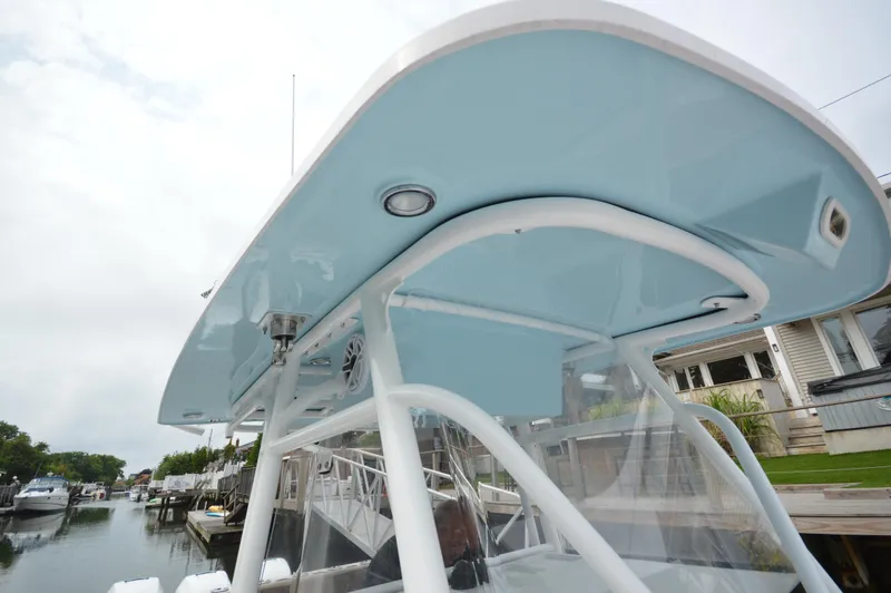 Slide: The Image of 2017 Fountain 38 Center Console boat with blue hardtop at a marina. - 19