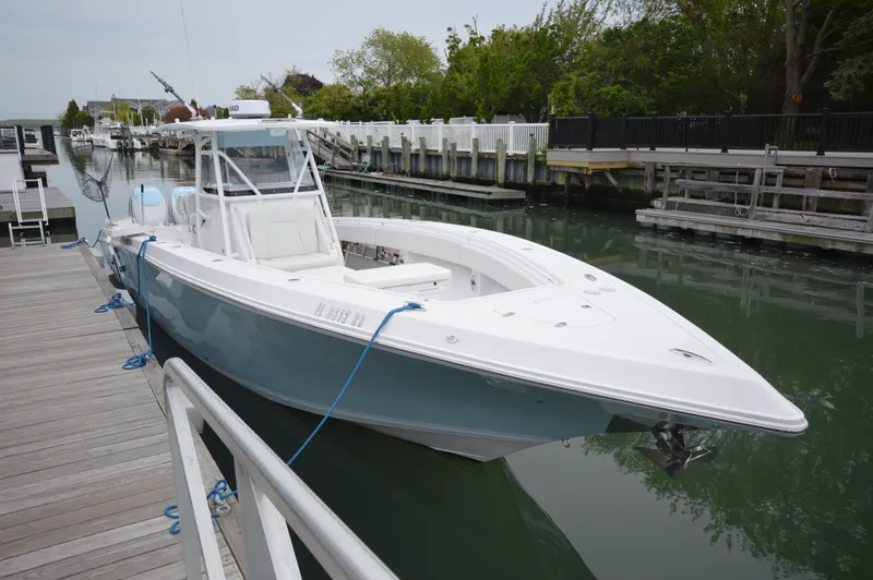Slide: The Image of 2017 Fountain 38 Center Console boat docked in a serene marina setting. - 4