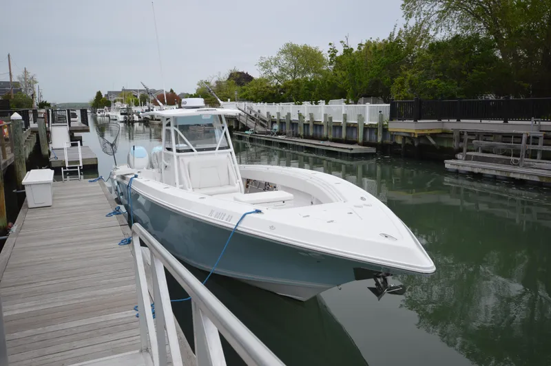 Slide: The Image of 2017 Fountain 38 Center Console boat docked in a serene marina setting. - 5